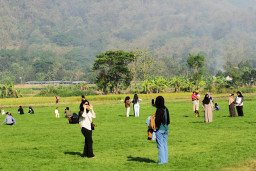 Sejumlah warga berwisata di sabana (padang rumput) di dasar Danau Gantiwarno yang mengering di Kabupaten Klaten, Jawa Tengah, Minggu, (26/7/2026). Berita Foto/Patrik Cahyo Lumintu